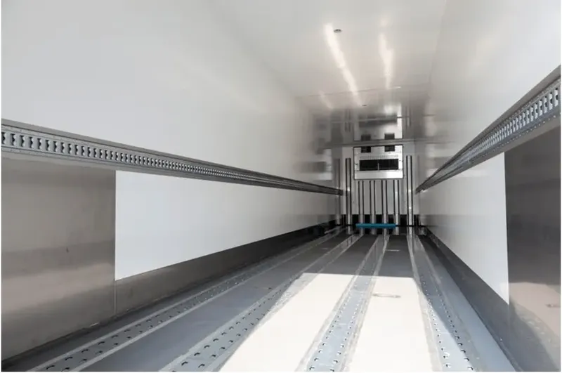 Interior of a refrigerated truck body with rails and ribbed aluminum floor