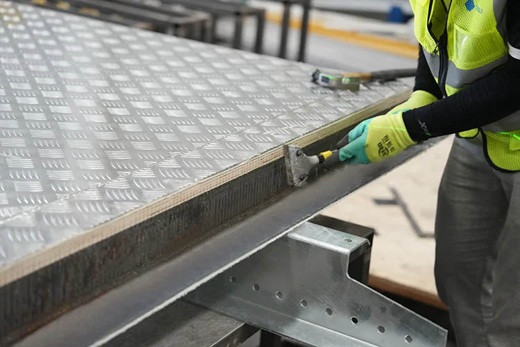 Technicians fabricating a ribbed aluminum refrigerated body floor